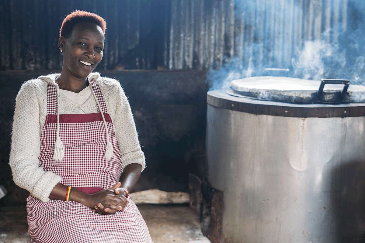 Empowering education through sustainability_Woman sitting next to DGBs cookstove in a kitchen_visual 3