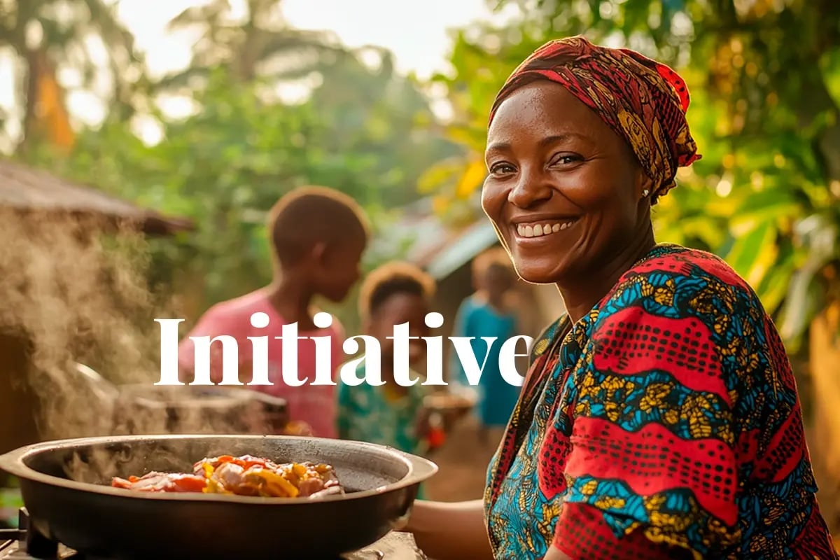 Nigeria eyes carbon revenue with nationwide cookstove rollout_A Nigerian woman cooking a meal on an energy-efficient cookstove, with her happy family playing in a green backyard_visual 1