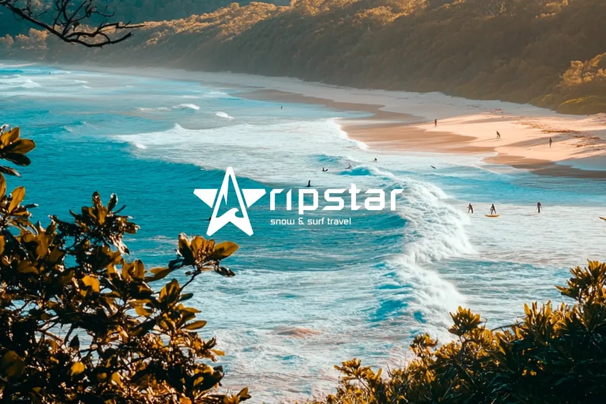 Ripstar’s green ride, taking action for adventure and the planet_A landscape photograph of a group of surfers surfing along an ocean shore_visual 1