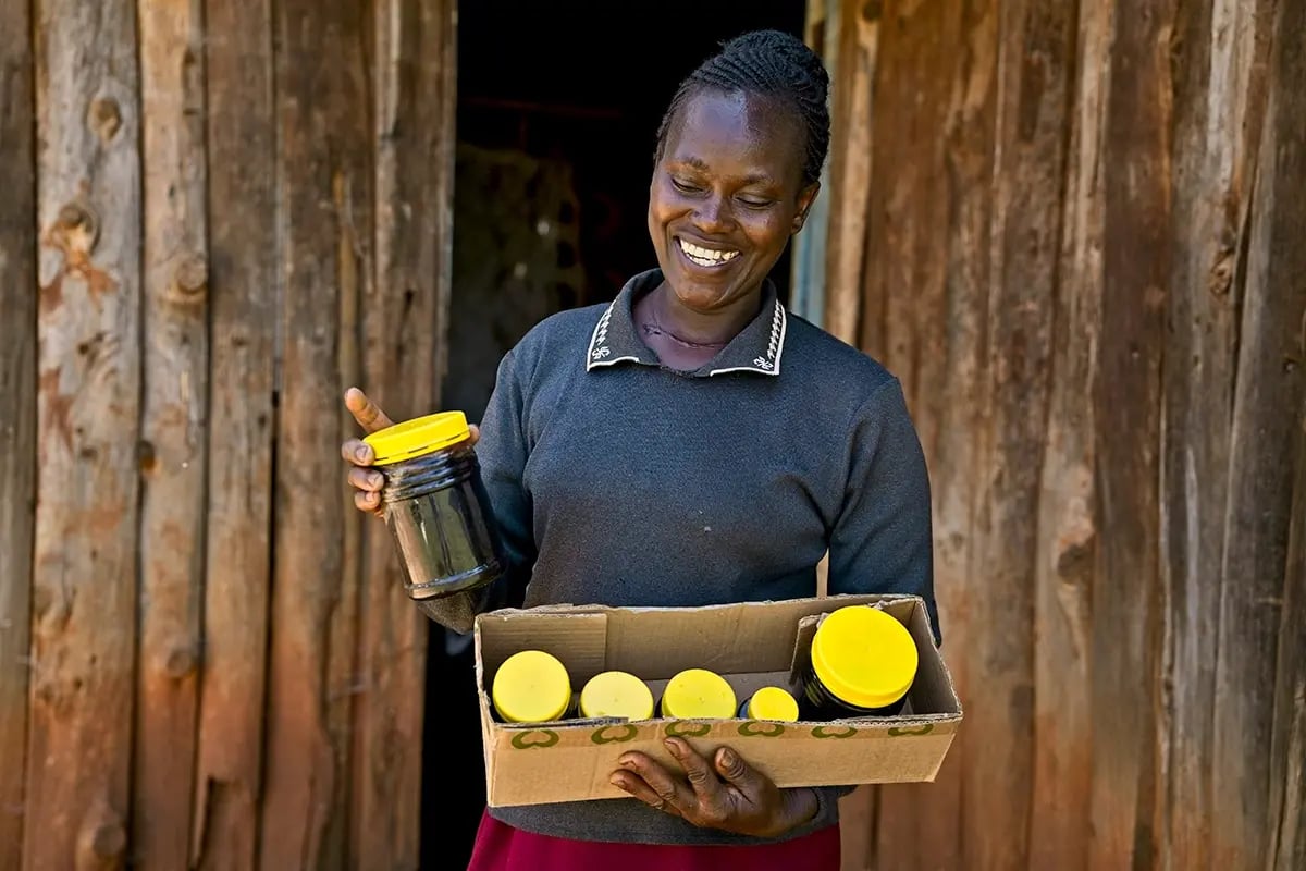 Sweet solutions_ the role of bees and Impact Investments in environmental restoration_A woman from a local community holding jars of honey_visual 2