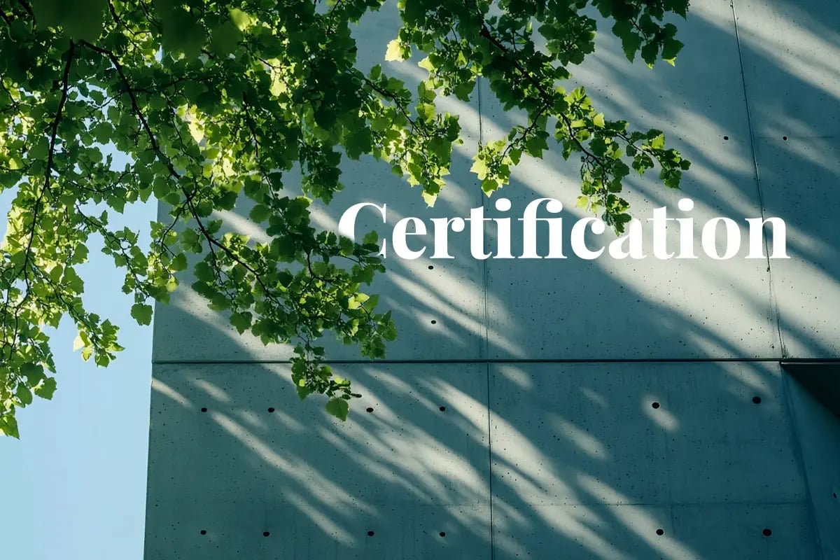 Swiss registry certifies biochar carbon storage in concrete_A modern building with a concrete finish, surrounded by green deciduous trees_visual 1